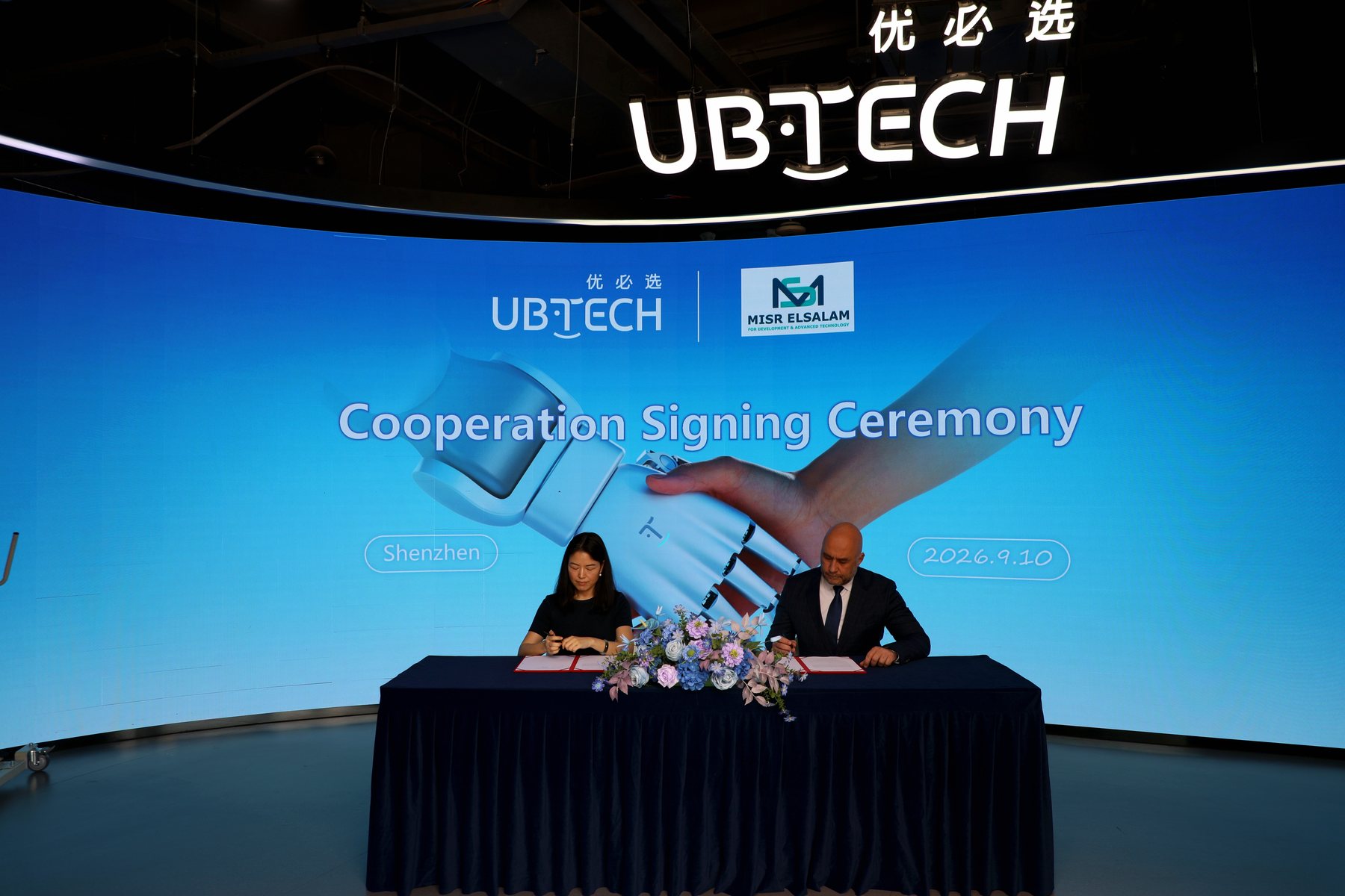 The cooperation agreement being signed at the ceremony table in Shenzhen